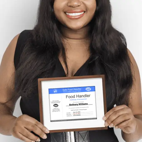 A woman proudly displays a food handler certificate, symbolizing her expertise in safe food handling.