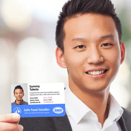 A man holding a business card, ready to exchange contact information in a professional setting.